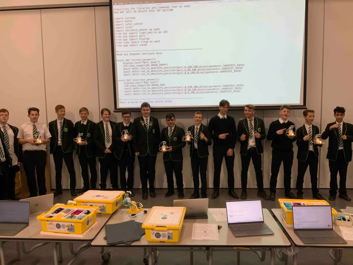 Secondary students writing Python code to control robots